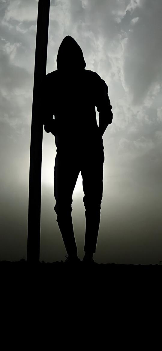 Hooded Silhouette Against Sky